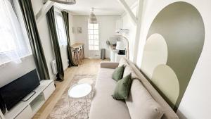 a living room with a couch and a table at Le Kaki Bohème - Studio proche Université de Paris 13 in Villetaneuse