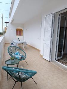 a balcony with a blue chair and a table at Mare a Sud in Villaggio Azzurro