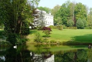 a house with a pond in front of a house at La Maison du Cavalier, Chateau de lAvenue in Pierrefitte-en-Auge