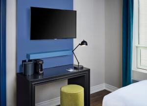 a bedroom with a desk with a tv and a stool at Hotel Victoria in Toronto