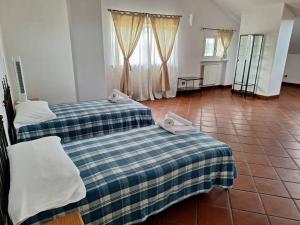 a room with two beds and a tile floor at Appartamento a due passi dal golf in Fubine