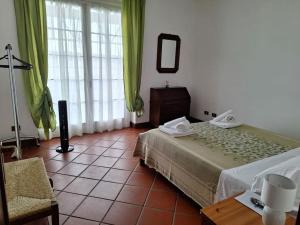 a bedroom with a bed and a chair and a mirror at Appartamento a due passi dal golf in Fubine