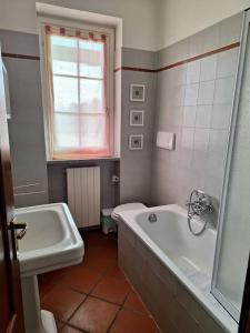 a bathroom with a tub and a toilet and a sink at Appartamento a due passi dal golf in Fubine