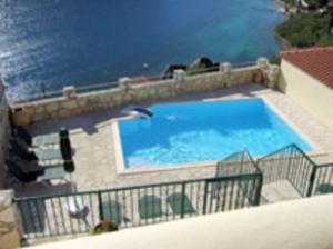 KournásにあるVilla Splendid, Kavallos, Lake Kournas presented by Ourvillasincreteの水辺の水泳場を飛ぶ鳥