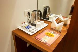 a table with a coffee maker and a tea kettle at Hotel Arch Suites - Near Aerocity in New Delhi