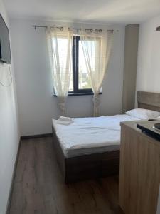 a small bedroom with a bed and a window at Garsoniera Luca in Drobeta-Turnu Severin