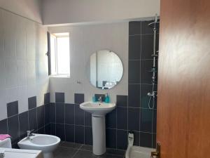 a bathroom with a sink and a toilet and a mirror at Seaside Gem in Sarandë +25 photos
