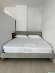 a bed in a white room with a white mattress at Seaside Gem in Sarandë