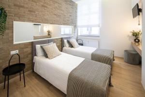 um quarto com 2 camas e uma parede de tijolos em Beautiful Apartment with 2 bedrooms for 7 guests, Jewish District em Cracóvia