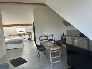 eine Küche und ein Wohnzimmer mit einem Tisch im Zimmer in der Unterkunft Hof Busen Landhaus Ap. oben links in Mönchengladbach