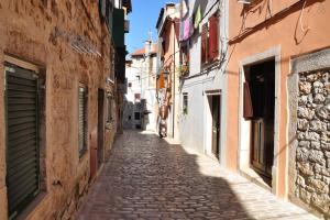 an empty street in an alley with buildings at Central Apartment Adria in Rovinj