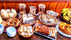 una mesa con muchos tipos diferentes de pan y repostería en Pousada Casa dos Sonhos, en Campos do Jordão