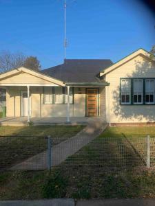 a white house with a fence in front of it at Golden Street Cottage in West Wyalong