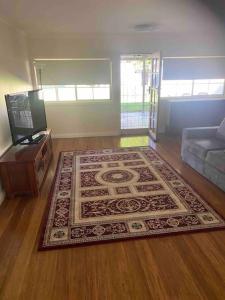 a living room with a rug on the floor at Golden Street Cottage in West Wyalong