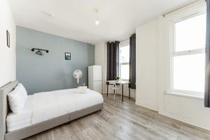 Leyton Comfy Double rooms - 50 في لندن: غرفة نوم بيضاء بها سرير ونافذة