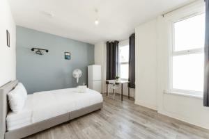 a white bedroom with a bed and a window at Leyton Comfy Double rooms -50 in London