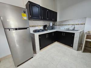 kuchnia z czarnymi szafkami i lodówką ze stali nierdzewnej w obiekcie Apartamento En La Circunvalar Por Parceros Group w mieście Pereira