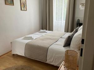 a bedroom with a bed with white sheets and a window at Three Rings Apartments in Karlovy Vary
