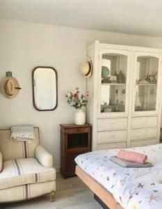 1 dormitorio con cama, silla y espejo en White Sand Beach, en Bergen aan Zee