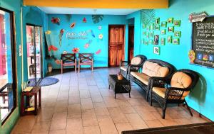 um quarto com uma parede azul com cadeiras e uma mesa em Tortuguero Adventures Beach House em Tortuguero