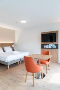 sypialnia z łóżkiem, stołem i krzesłami w obiekcie Villa Thermae Nancy w Nancy