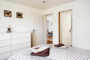 a white bedroom with a bed and a mirror at GLARNER Bed in Netstal