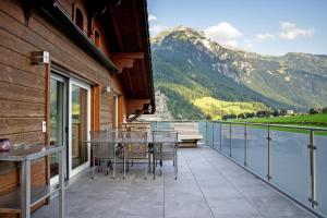 a balcony with tables and chairs and a view of a mountain at GLARNER Bed in Netstal