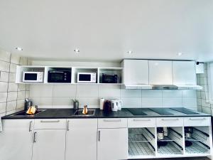 a kitchen with white cabinets and white appliances at Monteurzimmer ZIMMERzuVERMIETEN in Bäriswil in Bäriswil