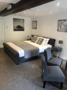 a bedroom with a large bed and a chair at Ramblers Rest in Castleton