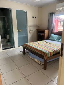 a bedroom with a bed and a sliding glass door at Casa Férias Paraty - yeshua in Paraty +8 photos