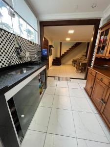 uma cozinha com um lavatório e piso em azulejo em Casa Férias Paraty - yeshua em Paraty
