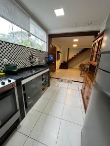 a kitchen with a large white tile floor at Casa Férias Paraty - yeshua in Paraty