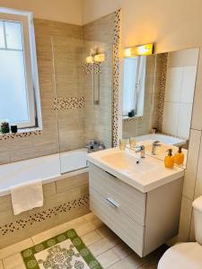 een badkamer met een wastafel, een bad en een toilet bij MVS Apartment in Giroc