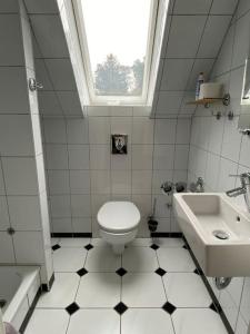 a white bathroom with a toilet and a sink at Dachwohnung mit Wasserblick und eigenem Bootssteg in Berlin