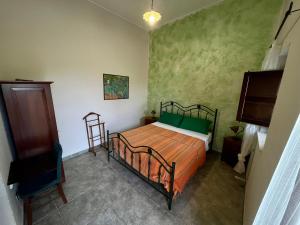 een slaapkamer met een bed met oranje en groene lakens bij Agriturismo Serre in SantʼAgata di Militello