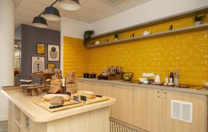 a bakery with yellow walls and a counter with bread at Appart Hotel Odalys City Le Havre Centre Les Docks in Le Havre