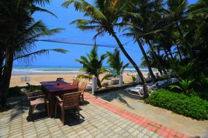 a wooden table and chairs on the beach at Jagabay Resort & Surfing School in Weligama