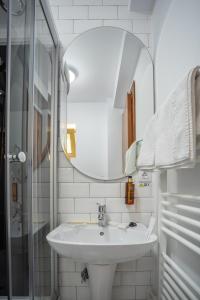 a white bathroom with a sink and a mirror at Opus View in Sinaia
