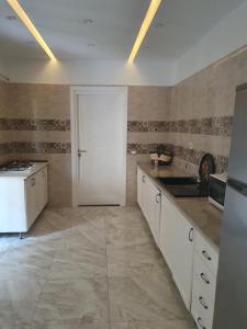 a kitchen with white cabinets and a white door at Grand appart. Carthage Salammbô in Tunis