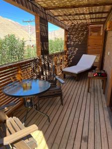 eine Terrasse mit einem Tisch und Stühlen auf einer Holzterrasse in der Unterkunft Cabañas Miraelqui in Pisco Elqui