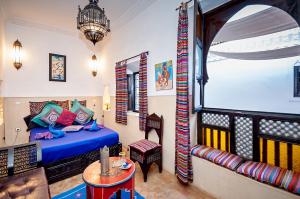 a bedroom with a bed and a couch in a room at Riad Dar Nadwa in Marrakesh