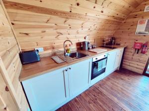 a kitchen in a log cabin with a sink at Saints' Meadow in Crich