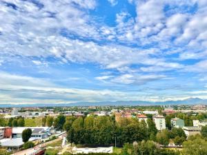 a city under a blue sky with clouds at Skyscraper 11 in Cinisello Balsamo