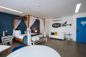Kembali Hotel Porto de Galinhas - Adults Only في بورتو دي غالينهاس: غرفة نوم بسرير وطاولة وسرير