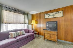 ein Wohnzimmer mit einem lila Sofa und einem TV in der Unterkunft Corning Vacation Rental with Private Fire Pit! 