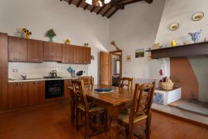 a kitchen with a wooden table and wooden chairs at Martignana in Empoli