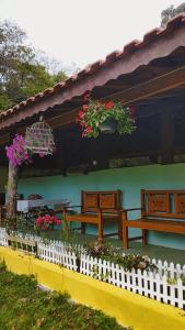 a white picket fence with flowers on a house at Rancho Maria Pimenta in Joanópolis +59 photos