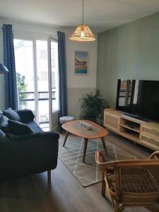 een woonkamer met een tafel en een televisie bij Appartement aux Portes de St Goustan in Auray