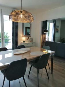 een eettafel en stoelen in de woonkamer bij Appartement aux Portes de St Goustan in Auray