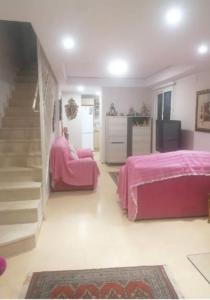 un dormitorio con camas rosas y una escalera en una habitación en Casa Carmen Martínez en Moncófar